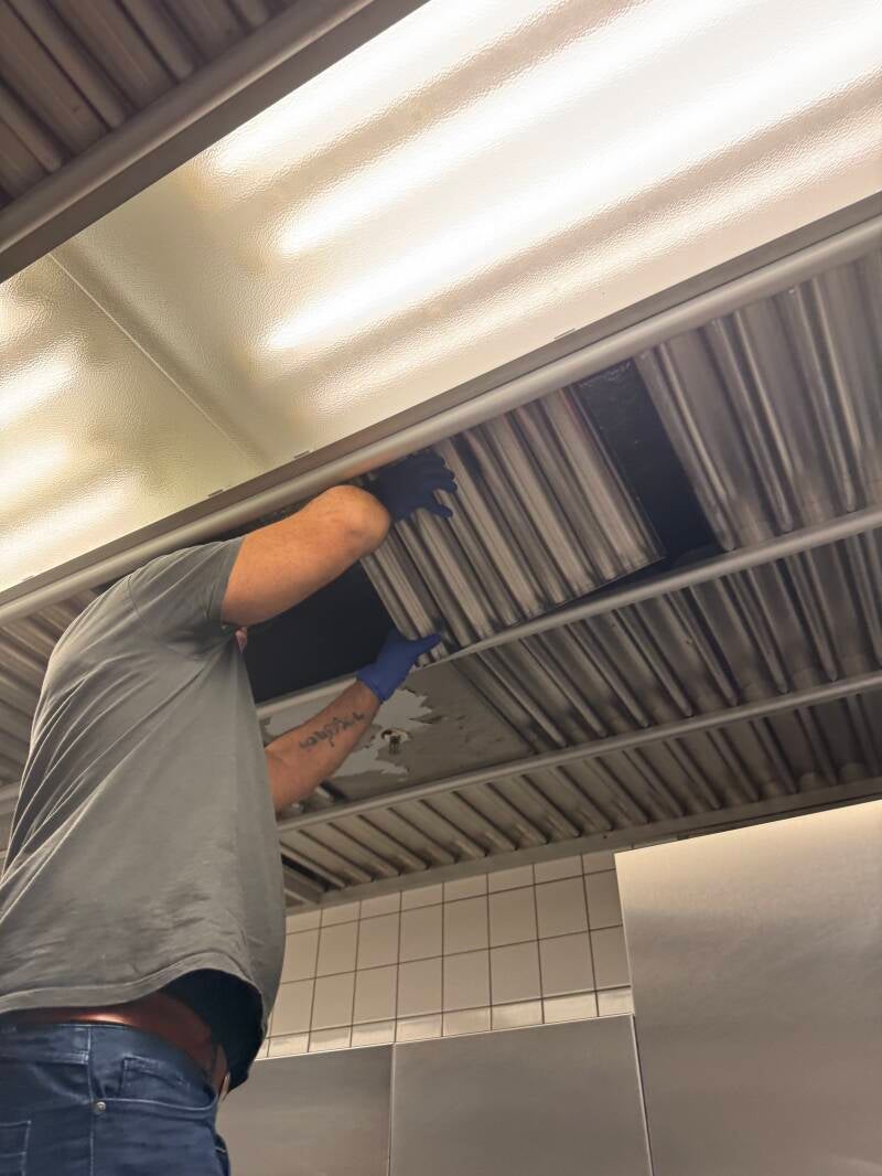 Arbeiten an herausnehmbaren Deckenelementen in einer gewerblichen Küche