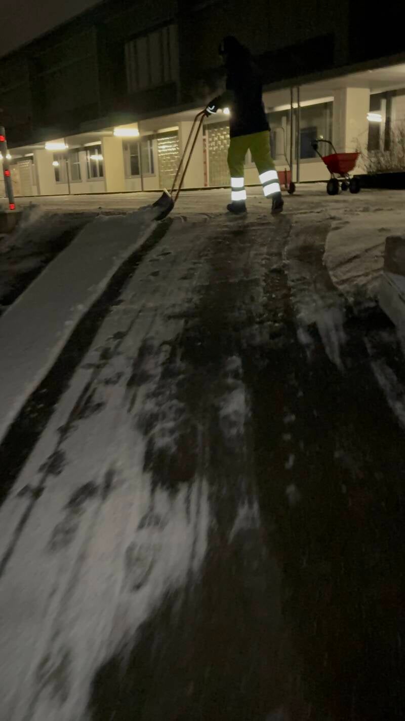 Schneeräumung mit Schneeschieber bei Dunkelheit